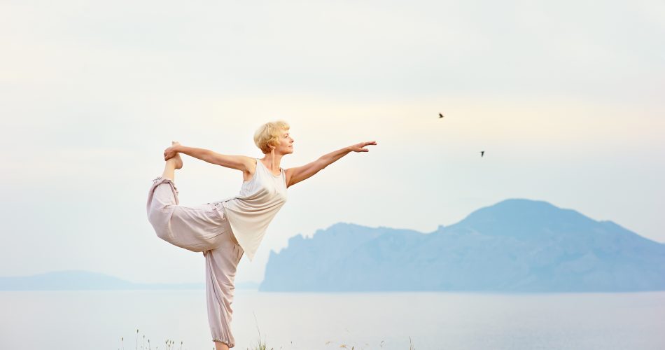 Senior,Woman,Doing,Yoga,Exercises,With,Mountain,On,The,Background